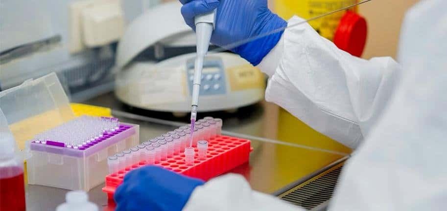 Laboratory technician loading reagents into a chemistry analyzer system.
