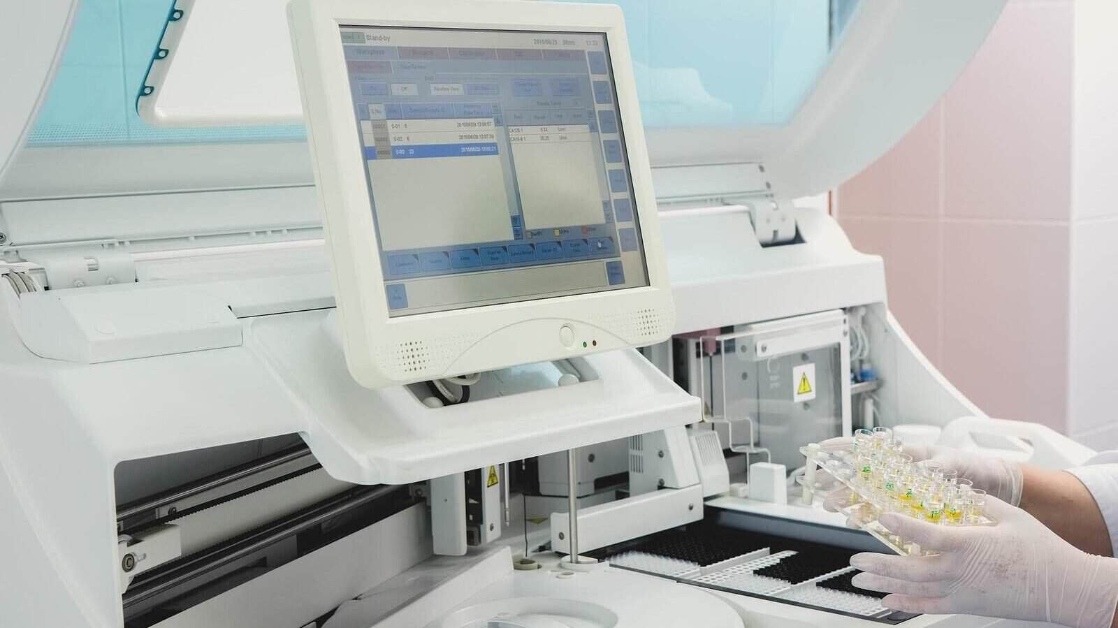 Biomedical engineer performing maintenance on a chemistry analyzer machine.